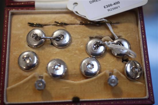 An early 20th century 9ct white gold, mother of pearl and diamond set eight piece dress stud set, in fitted box.